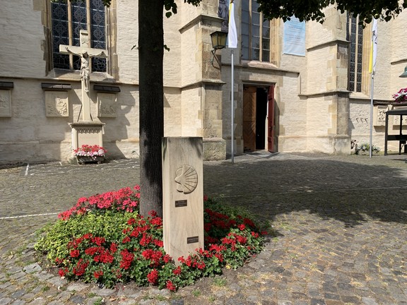Am Platz vor der Clemenskirche in Telgte findet sich ein Stein mit Pilgermuschel, der den Jakobsweg markiert.